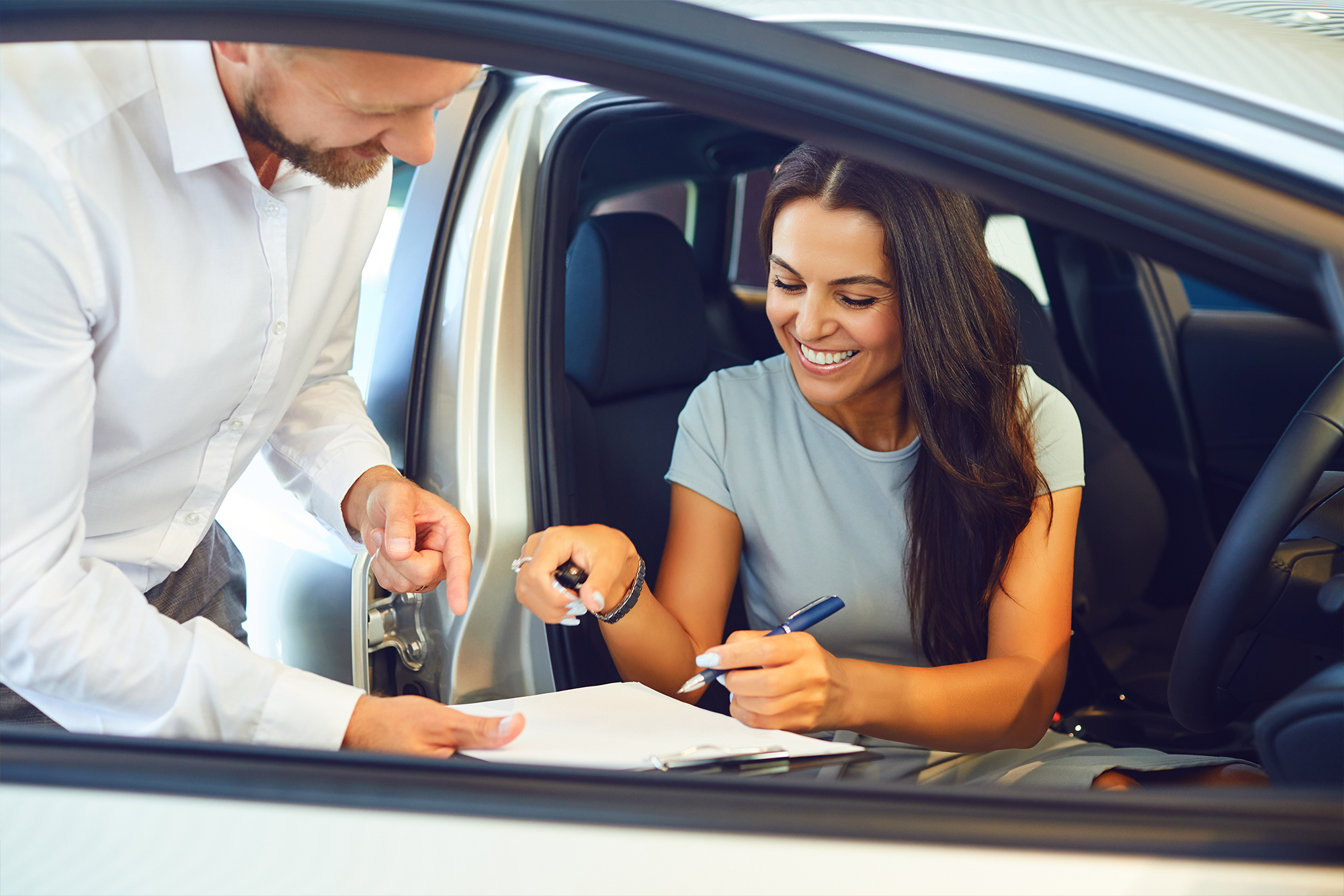 Customer signing agreement inside vehicle for long term car hire